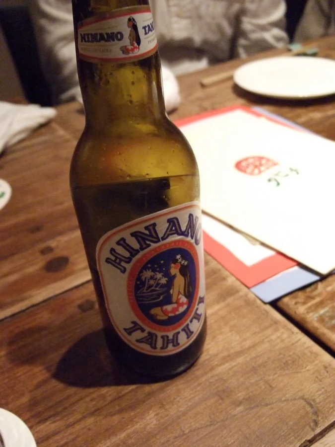 Bouteille de Hinano posée sur une table en bois